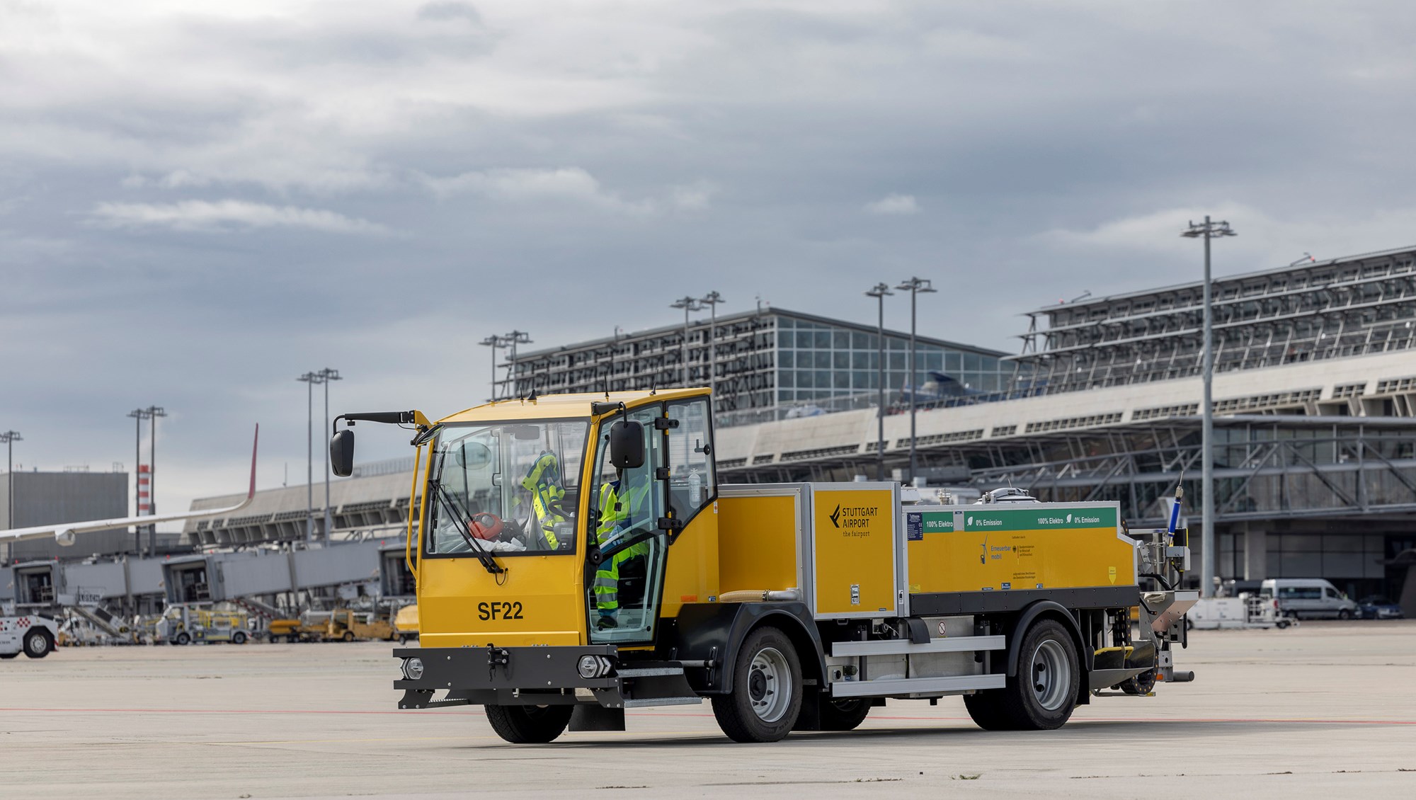 Ein elektrischer Abpumpwagen wird an ein Flugzeug angeschlossen.